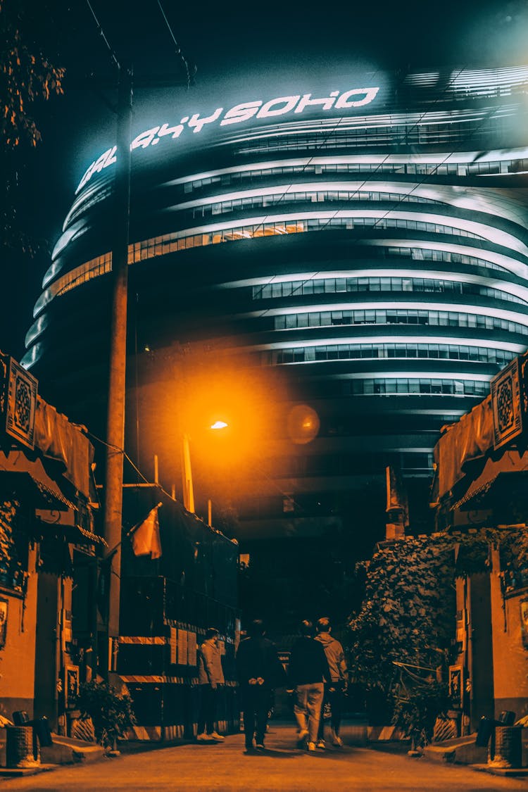 People Walking On The Street During Night Time Near Galaxy Soho Building