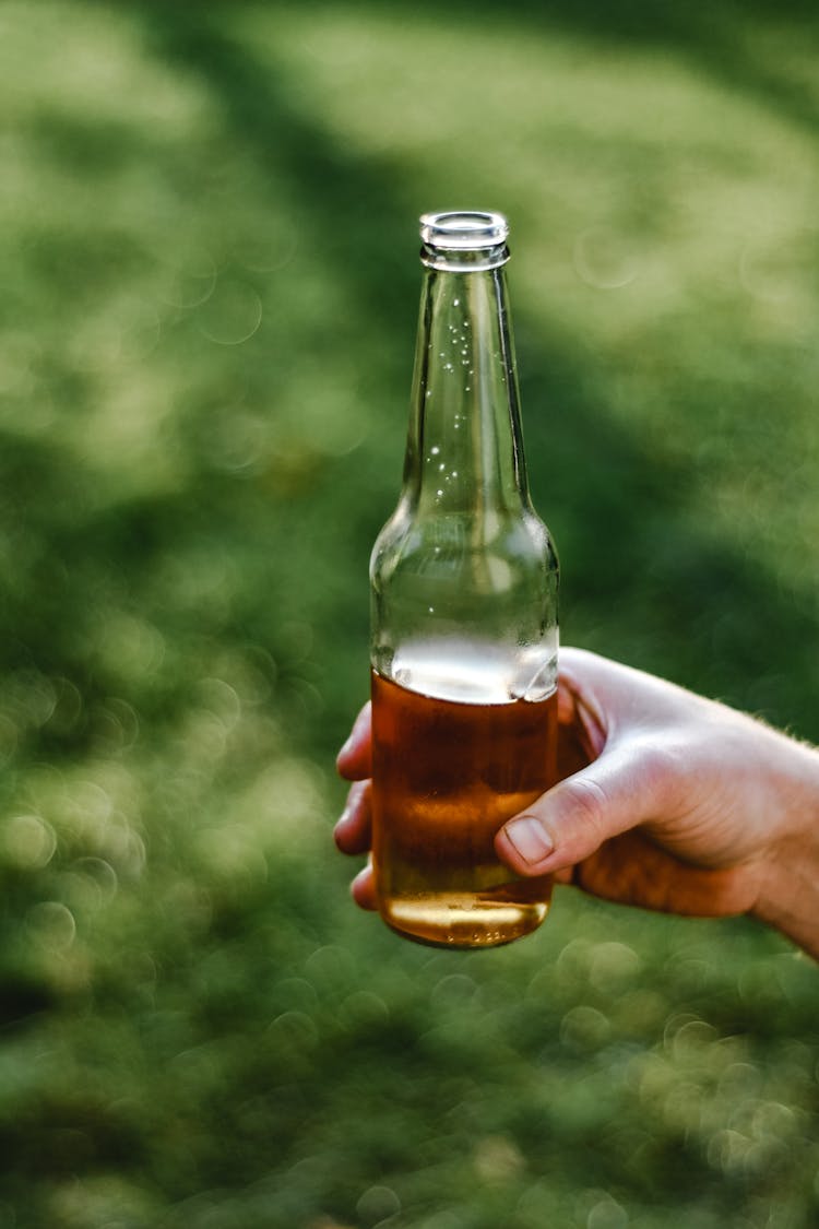 A Hand Holding A Bottle Of Beer