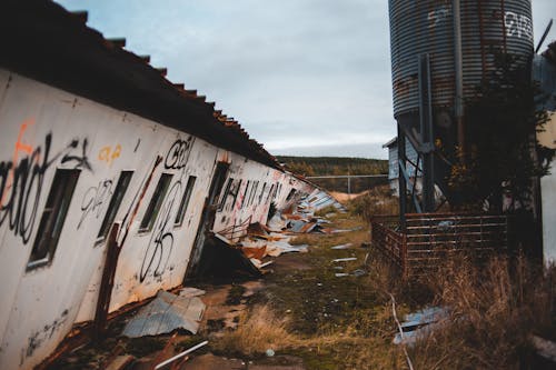 Abandoned buildings with inclined wall in countryside