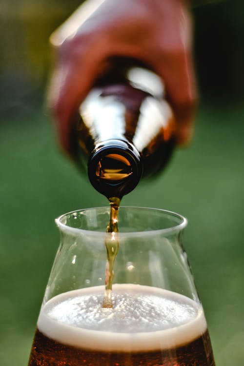 A Person Pouring Beer to a Glass 