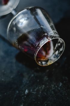 一张带有残余液体的玻璃杯在带纹理的深色背景上的详细照片