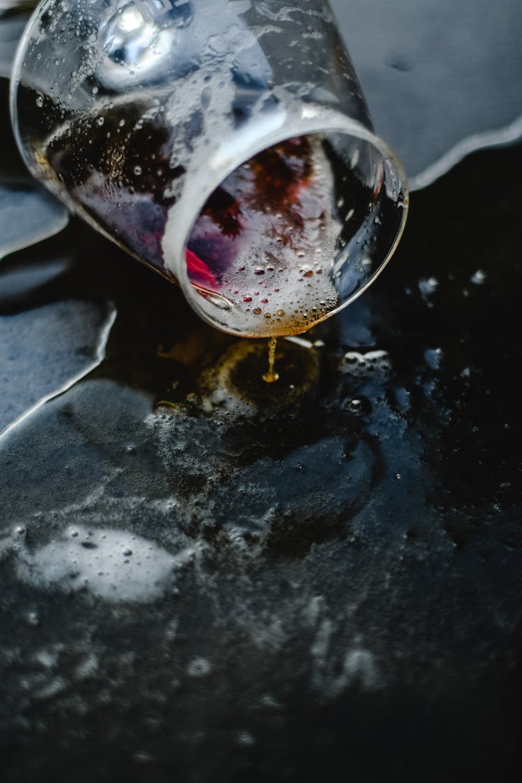 A Wine Glass Lying On The Floor With Spilled Wine