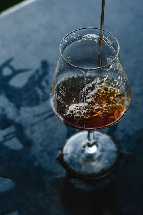  A Brown Drink Pouring in a Wine Glass