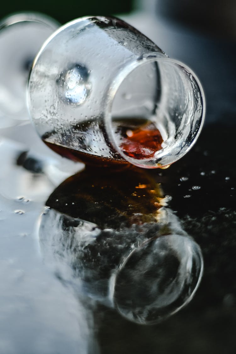 A Wine Glass Lying On The Floor With Spilled Wine
