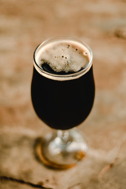 Free Vertical shot of a dark stout beer in a tulip glass, perfect for beverages and bar themes. Stock Photo