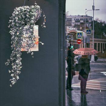 雨天里，城市街景与人们在雨伞下的倒影相互映衬