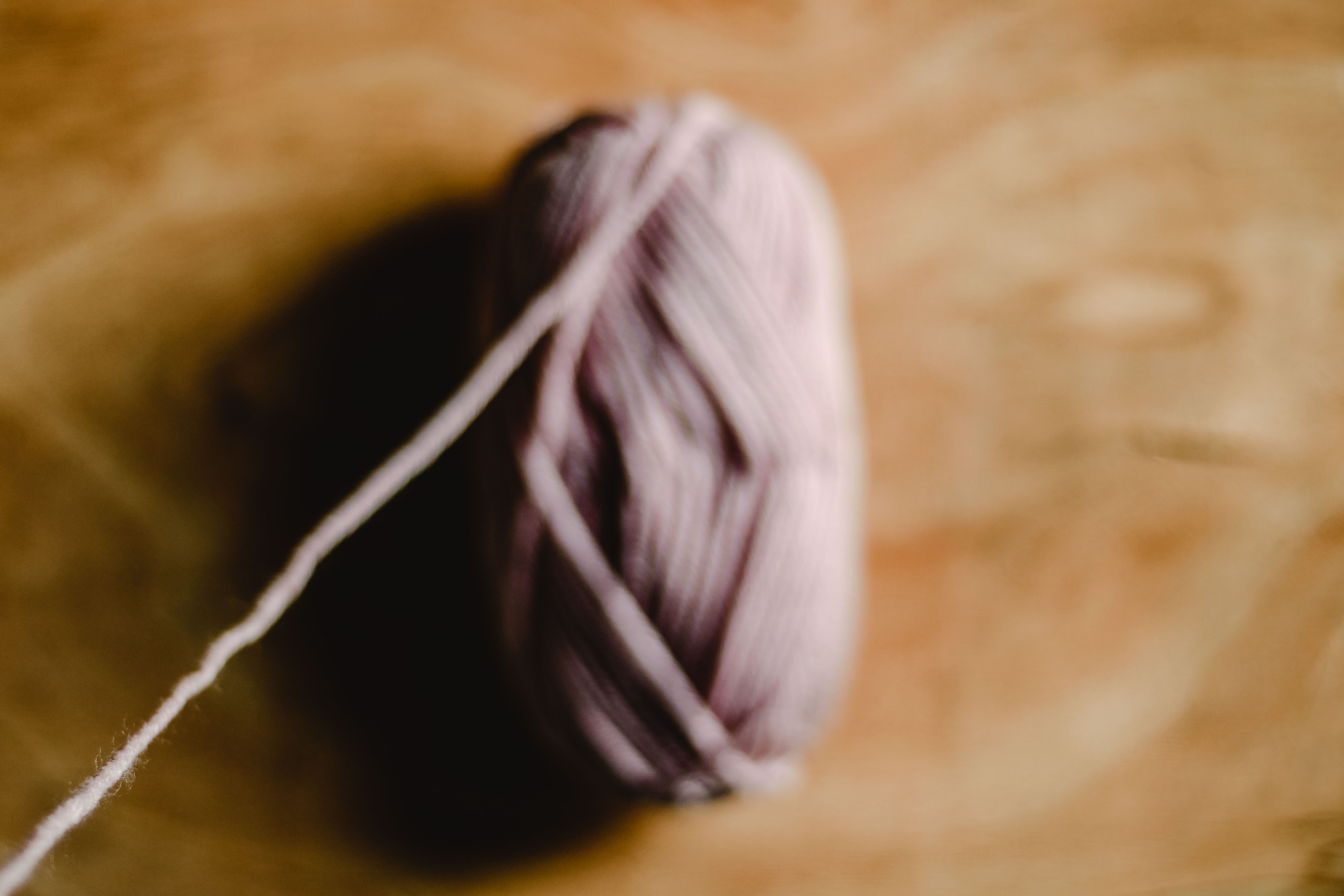 close-up comparison showing the smoother, tighter surface of a ring-spun yarn versus the fuzzier surface of a rotor-spun yarn