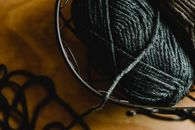 Black Yarn on Brown Wooden Table
