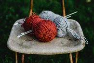 Red and Gray Yarn on Brown Wooden Table