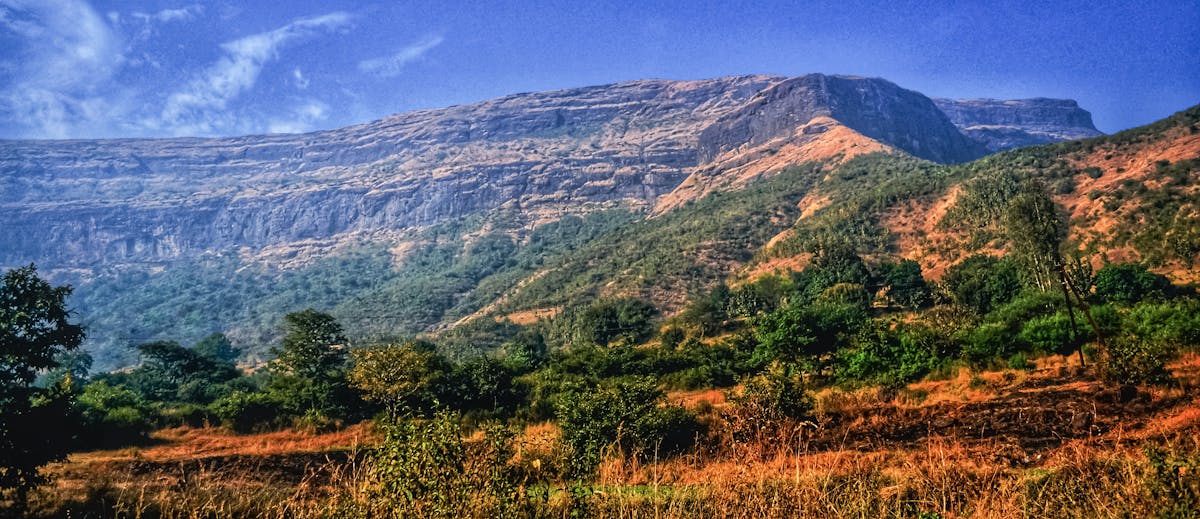 Person adjusting pillows and bedding on a neatly made bed