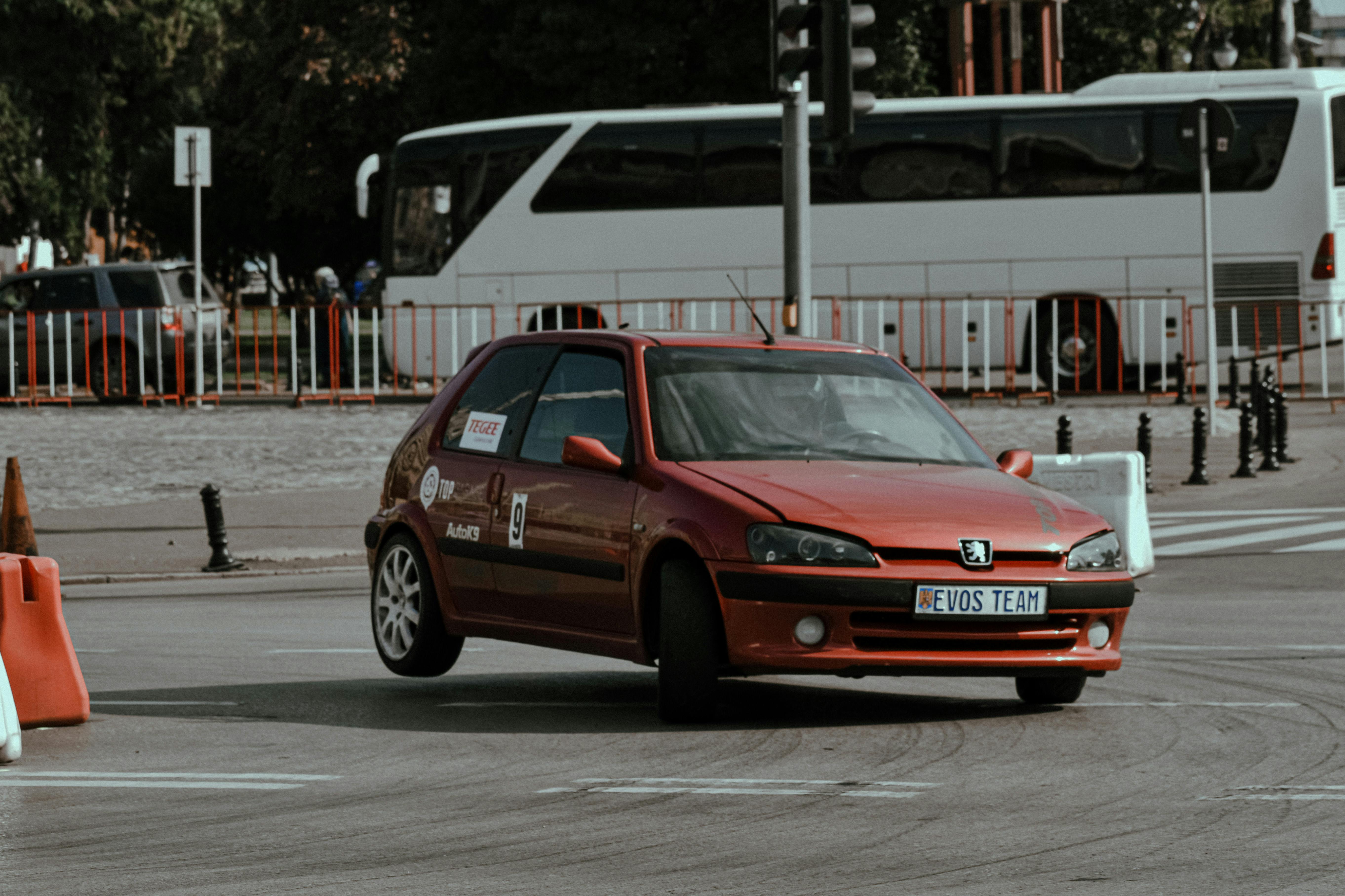 Free Dynamic shot of a red Peugeot car drifting during a city rally competition, showcasing speed and control. Stock Photo