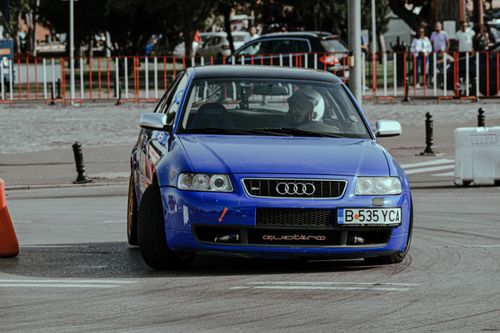 Free Driver in helmet sitting in blue car and driving fast while participating in city rally Stock Photo