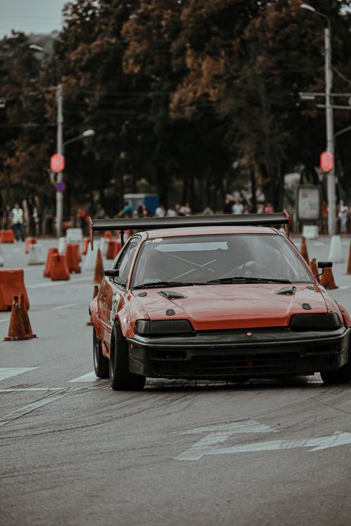 Free Old fashioned red car racing in urban rally and driving on asphalt roadway Stock Photo