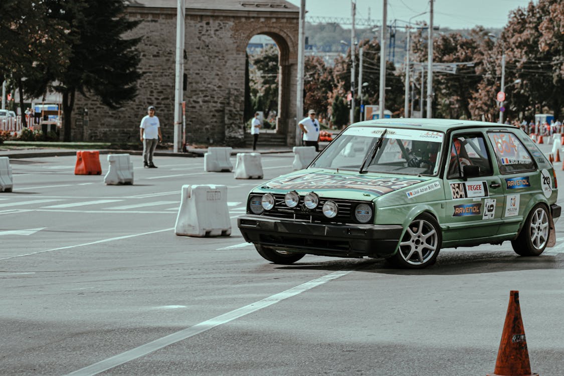 Retro car driving on road with barriers