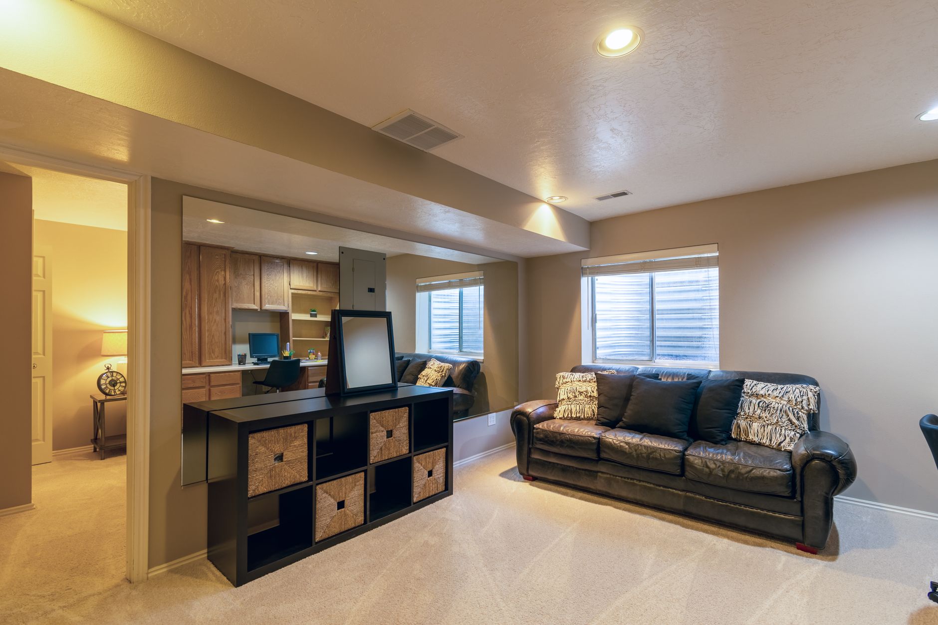 A warm, finished basement living room with a leather sofa in a legal Kitchener suite. A warm, finished basement living room with a leather sofa in a legal Kitchener suite.