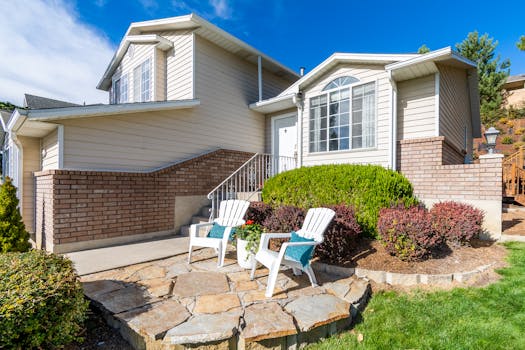 Elegant suburban house exterior with porch and seating area in bright daylight.