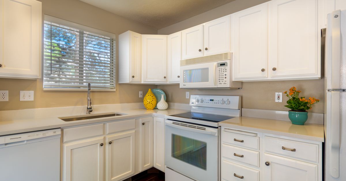Bright and clean white kitchen featuring modern appliances and sleek design.