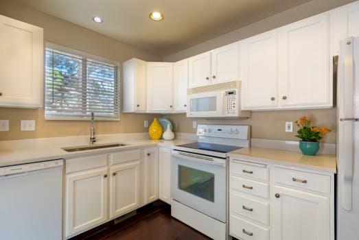 Bright and clean white kitchen featuring modern appliances and sleek design.