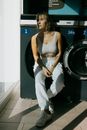 Young woman leaning on washing machine