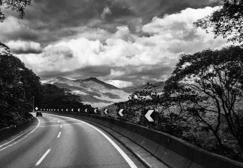 Grayscale Photo of Road Near Mountain