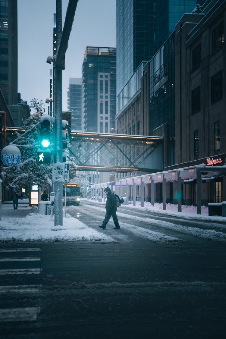 A Person Crossing The Road In Winter