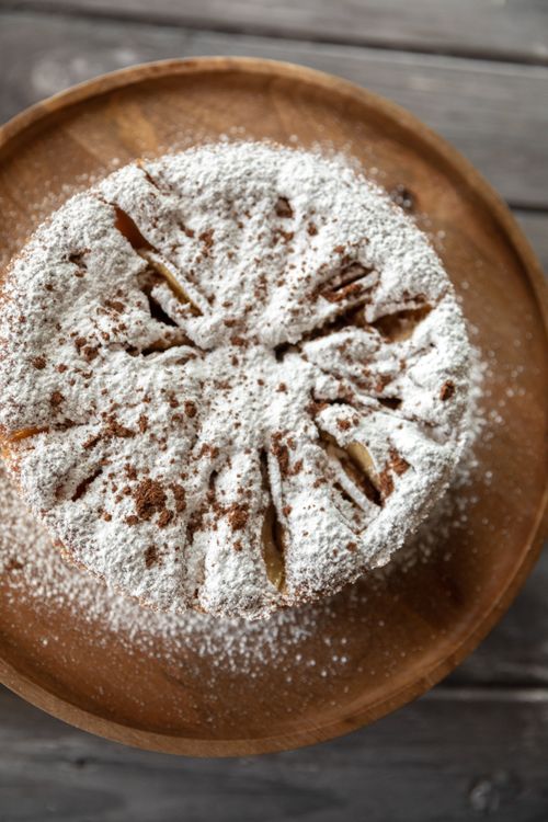 Free Delicious homemade apple cake topped with powdered sugar, perfect for a cozy dessert. Stock Photo
