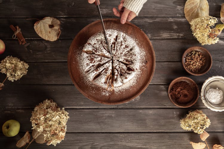 Top View Of A Hand Slicing A Round Cake 