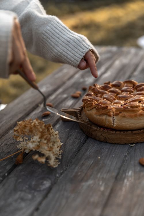 Free Cozy scene of a pie being served outdoors on a wooden table, capturing a warm and inviting atmosphere. Stock Photo