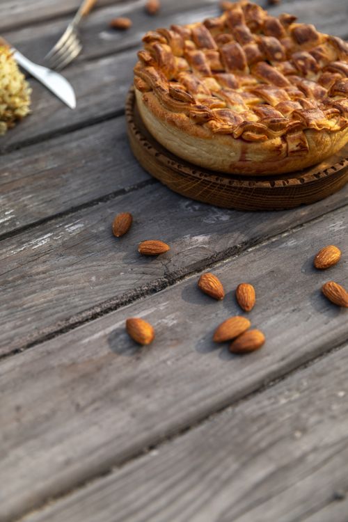 Free Delicious homemade almond pie with rustic crust on wooden table outdoors, perfect for dessert. Stock Photo