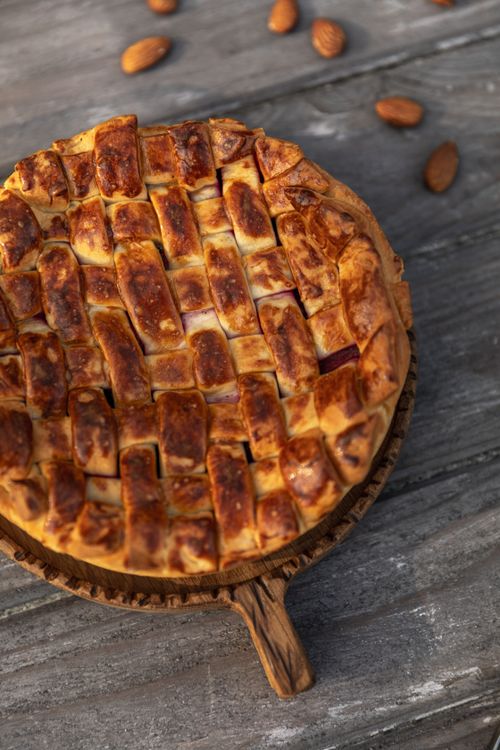Free Delicious homemade lattice pie on a rustic wooden background with almonds scattered around. Stock Photo