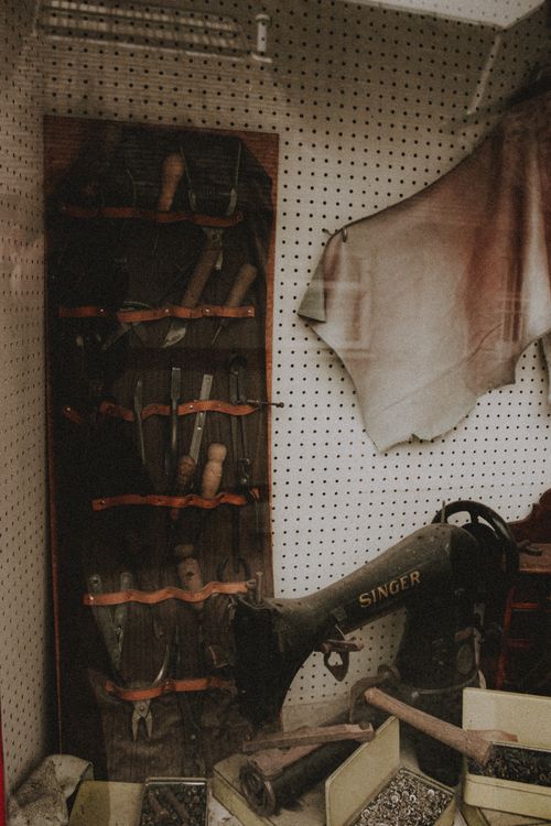 Free Collection of professional artisan instruments on wall near manual sewing machine and boxes with screws Stock Photo