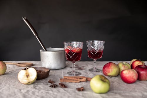 Apples and Cinnamon Sticks with Cooking Pot and Drink Glasses