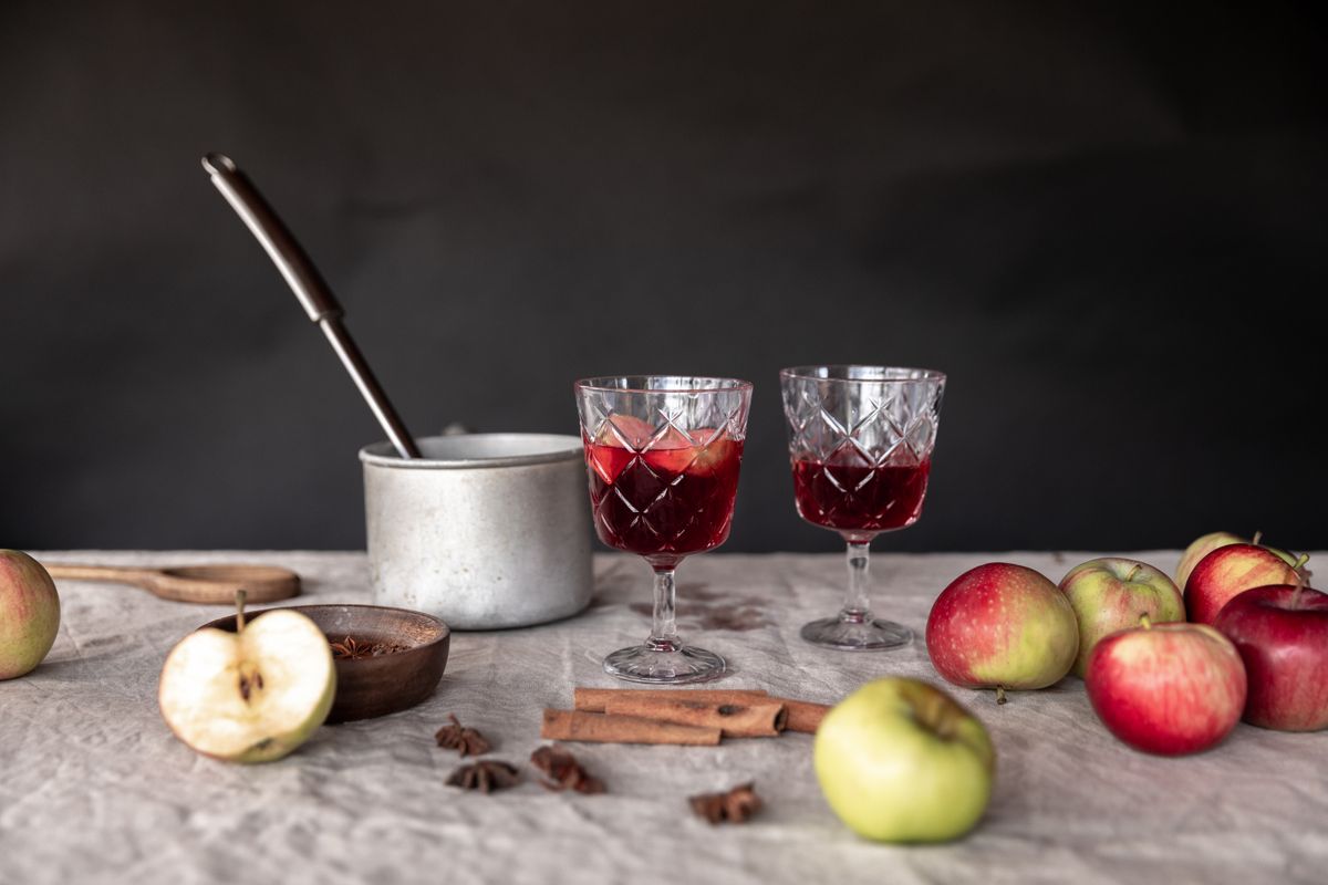Glasses of apple cider with cinnamon and autumn apples