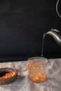 Person Pouring Liquid in a Glass Cup with Sea Buckthorns
