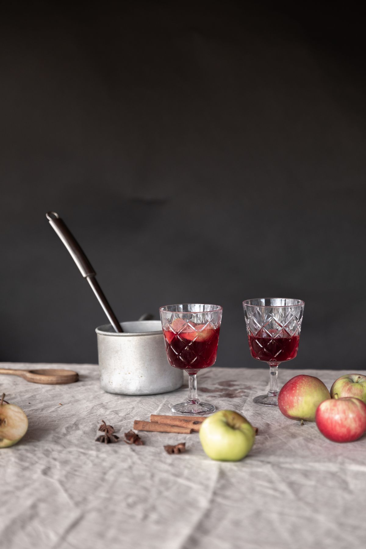 Two glasses of apple cinnamon mulled wine with fresh apples