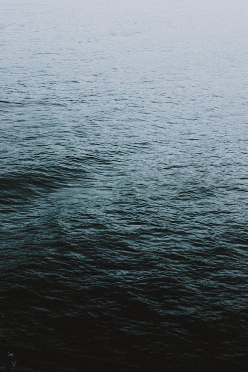 From above scenic view of rippled ocean with water flow in twilight on blurred background