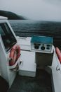 White motorboat floating on sea against misty mountains