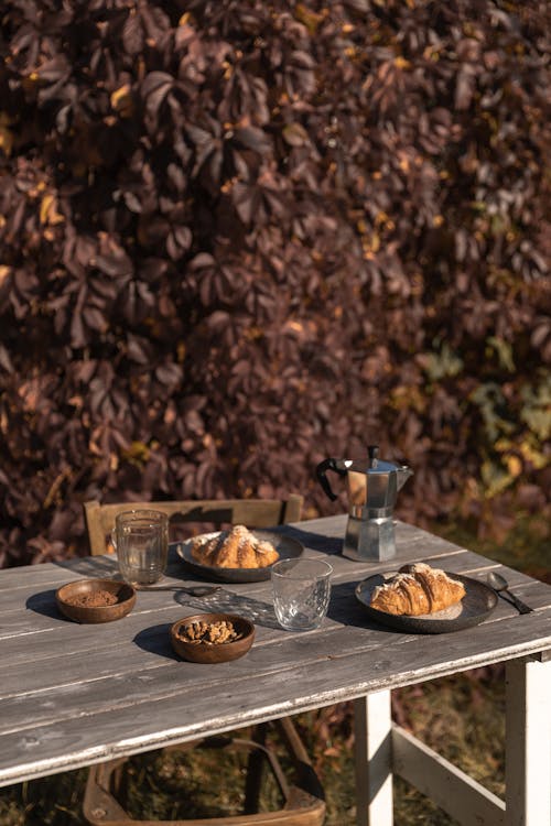 grátis Foto profissional grátis de croissants, mesa de madeira, nozes Foto profissional