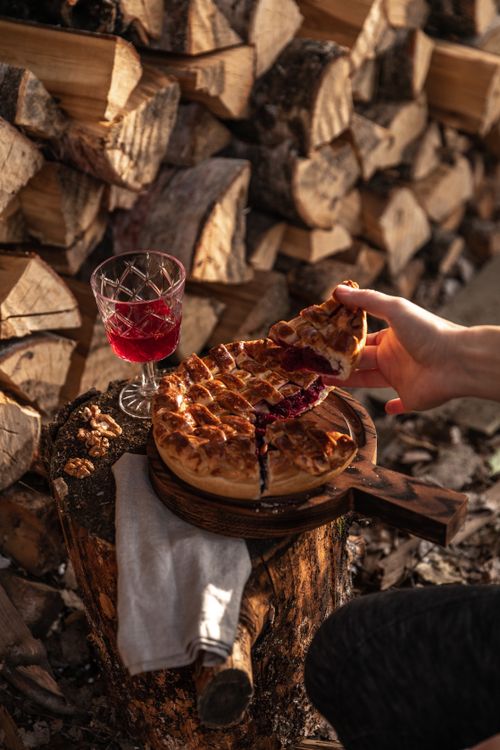 Free Cozy rustic setting featuring a fruit pie served with red wine, perfect for autumn evenings. Stock Photo