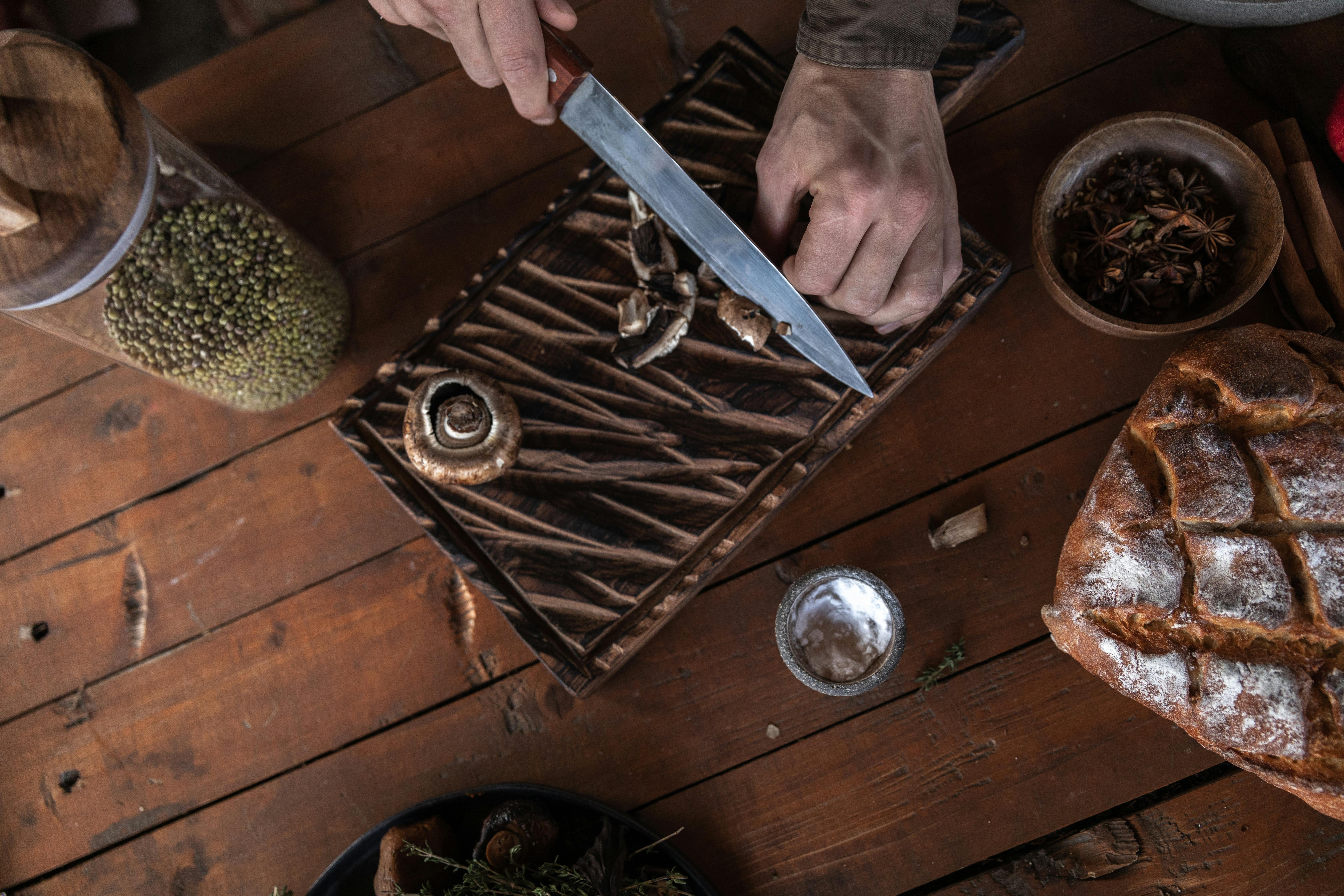 a person holding a knife cutting mushrooms