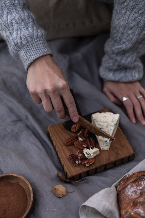Foto profissional grátis de amendoim, mãos, nozes