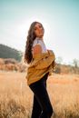 Stylish young woman standing gracefully in autumn field