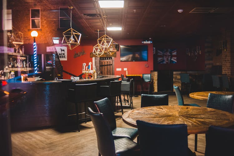 Interior Of Traditional English Pub With Wooden Tables And Leather Chairs