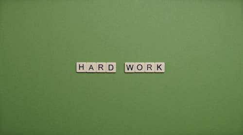 Free Hard Work Text On Green Background Stock Photo
