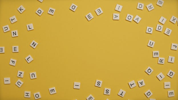 明亮的黄色背景上，分散的字母形成了圆形图案