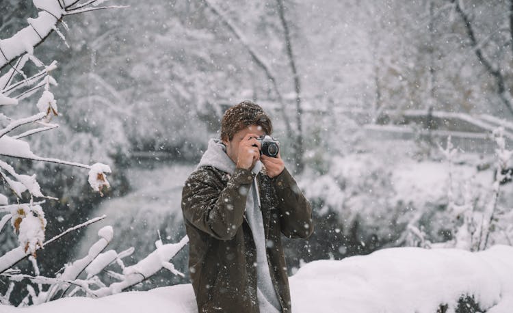 Man Taking Photo With Camera In Winter