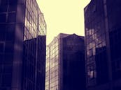 未来派的玻璃摩天大楼在城市环境中映照着天空，体现了现代建筑设计