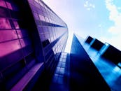 在蓝天的映衬下，低角度视角展现了充满活力的现代摩天大楼与城市建筑