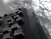 当代摩天大楼的低角度单色视图，展现了带有几何阳台和反光玻璃立面的设计