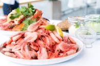 一盘点缀着柠檬和香草的虾和海鲜，非常适合享用